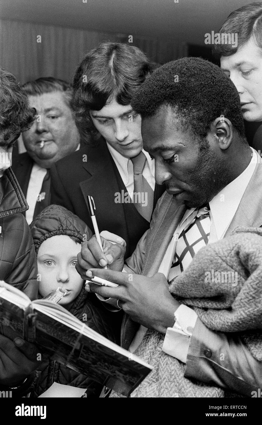 Calciatore brasiliano Edson Arantes do Nascimento, più famoso sa come Pele, raffigurato firma autografi per la città il calciatore Trevor Francesco dopo il suo arrivo in Birmingham. Febbraio 1972 Foto Stock