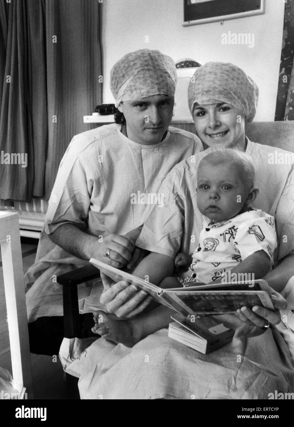 Un anno-vecchio Andrew Scullion recupera dal suo funzionamento con i genitori Lorena e Michael. Andrew soffre di deficienza immunitaria. 14 giugno 1988. Foto Stock