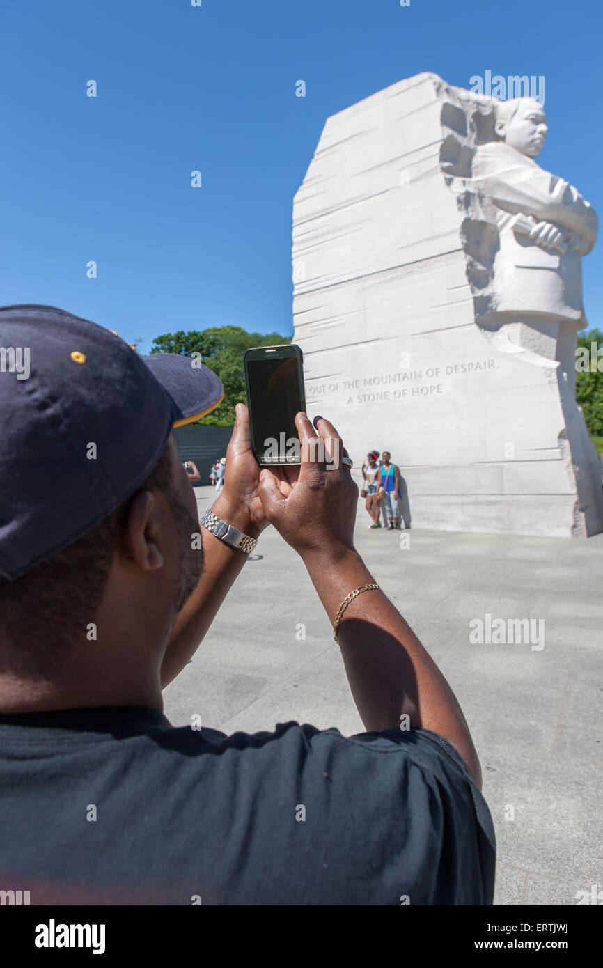 Un afro-americano di uomo utilizza uno smartphone per scattare una foto del memoriale di Martin Luther King a Washington, DC. Foto Stock