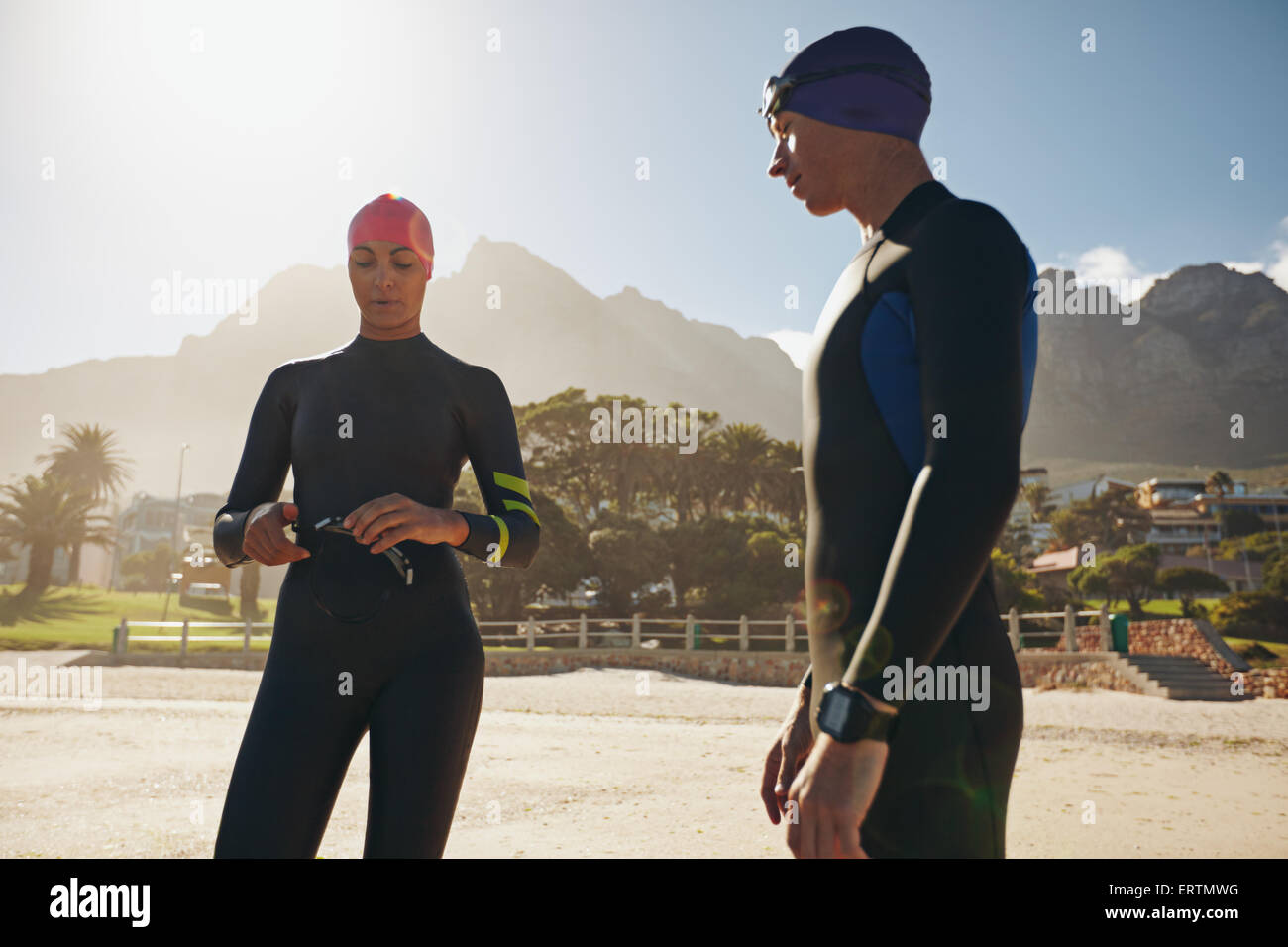 Colpo di giovane uomo e donna con la loro piscina e marcia su permanente sulla spiaggia. Triatleti la preparazione per la gara. Foto Stock