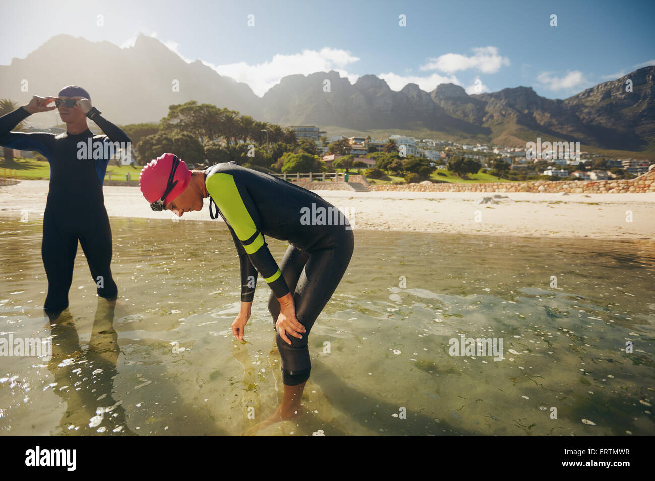 Gli atleti riposo dopo il triathlon la sessione di formazione. Giovane uomo e donna in piedi in acqua facendo una pausa dalla pratica. Foto Stock