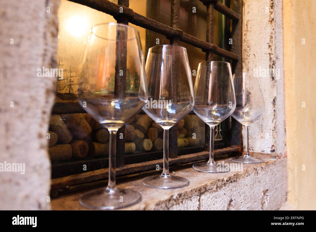 Quattro libere bicchieri di vino oltre a finestre fuori di una Cantina Veneta Foto Stock