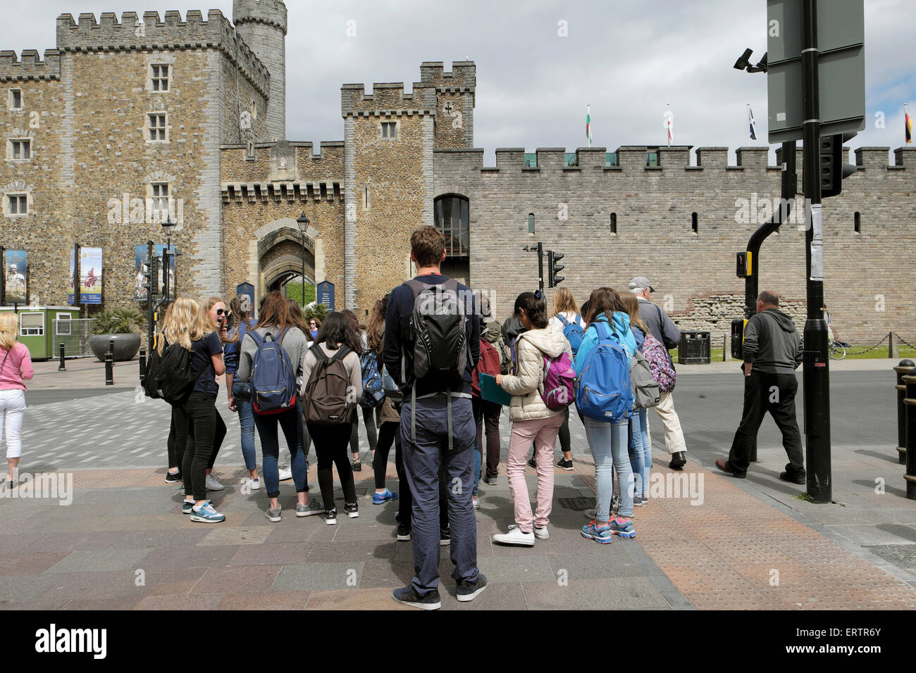 Un gruppo di studenti stranieri in attesa ad un semaforo sul loro modo di visitare il Castello di Cardiff in Galles UK KATHY DEWITT Foto Stock