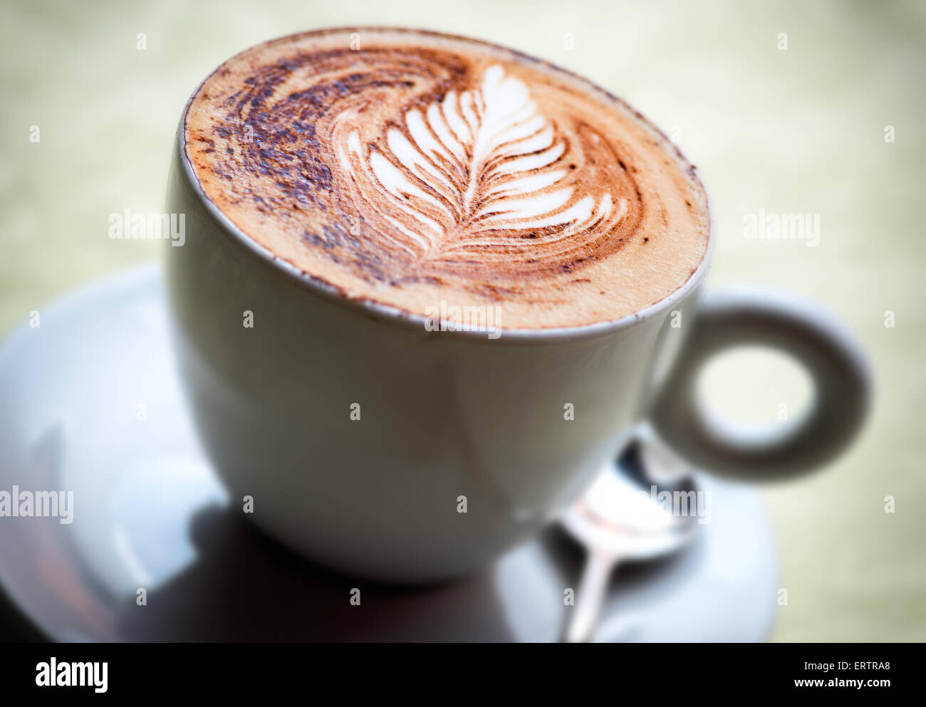 Una deliziosa tazza di hot cappuccino italiano caffè con una foglia decorativa pattern Foto Stock