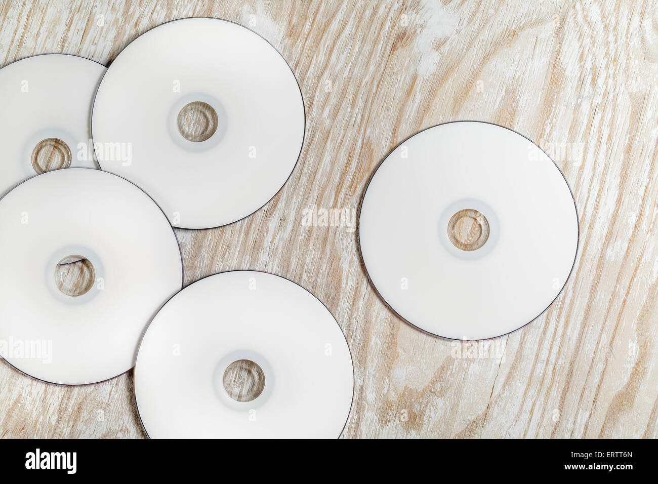 Blank printable CD e DVD su luce sullo sfondo di legno. Vista dall'alto. Foto Stock