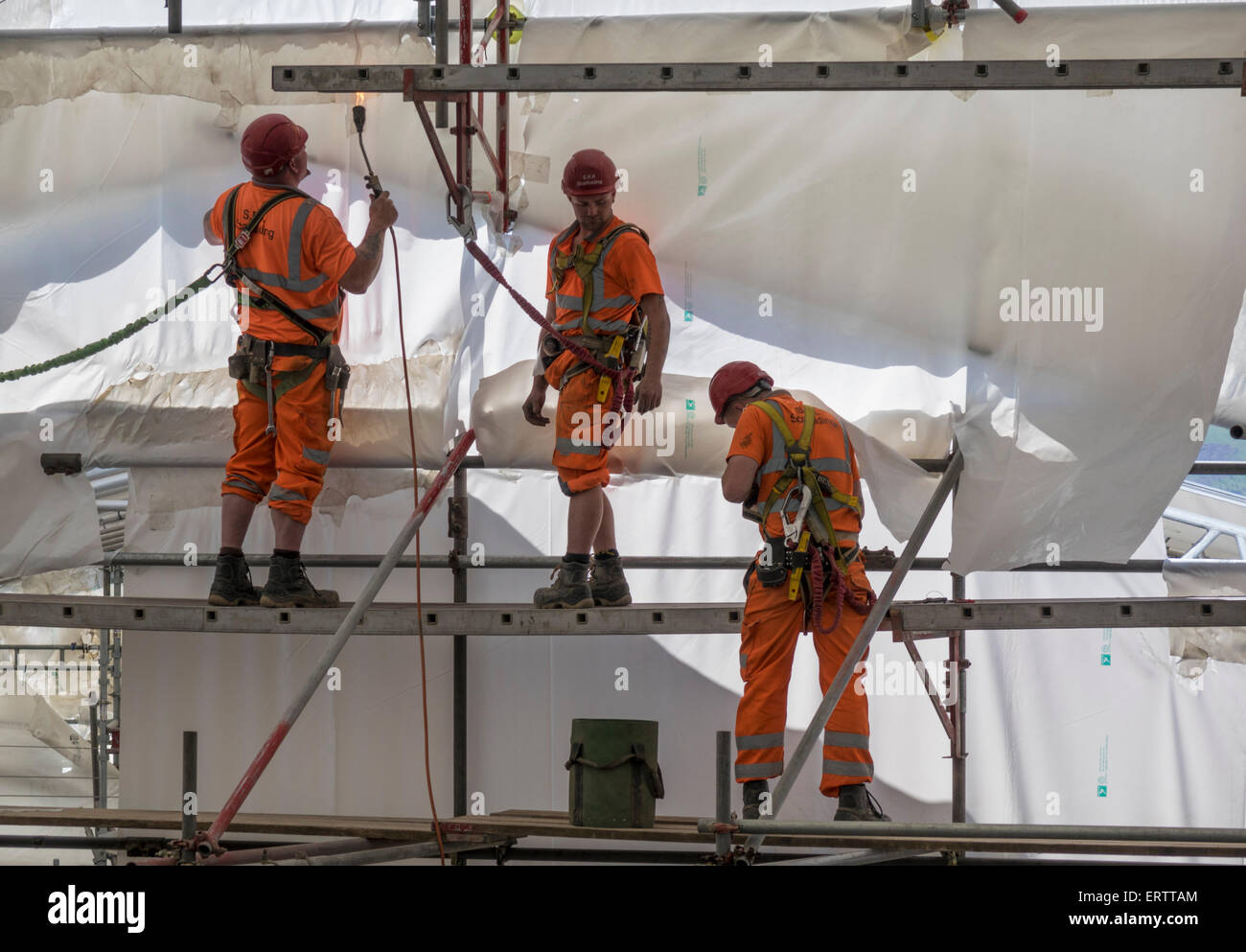 Lavoratori edili erigere impalcature e racchiude nella tenda di plastica per la protezione da condizioni atmosferiche, REGNO UNITO Foto Stock