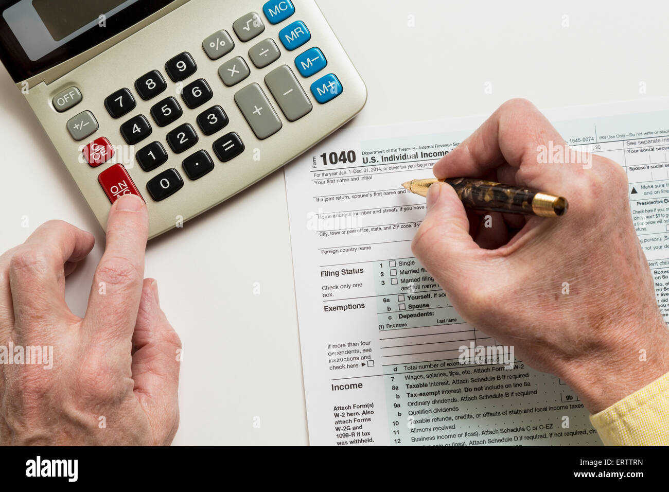 L'uomo il riempimento in USA sotto forma di imposta 1040 di ritorno con la calcolatrice - Concetto di tassazione Foto Stock
