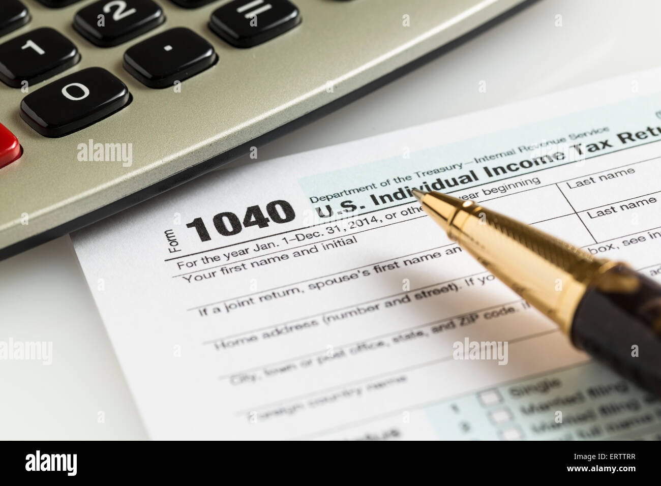 USA forma fiscale 1040 per l'anno 2014 con una penna e calcolatrice che illustra il completamento dei moduli fiscali per il IRS Foto Stock