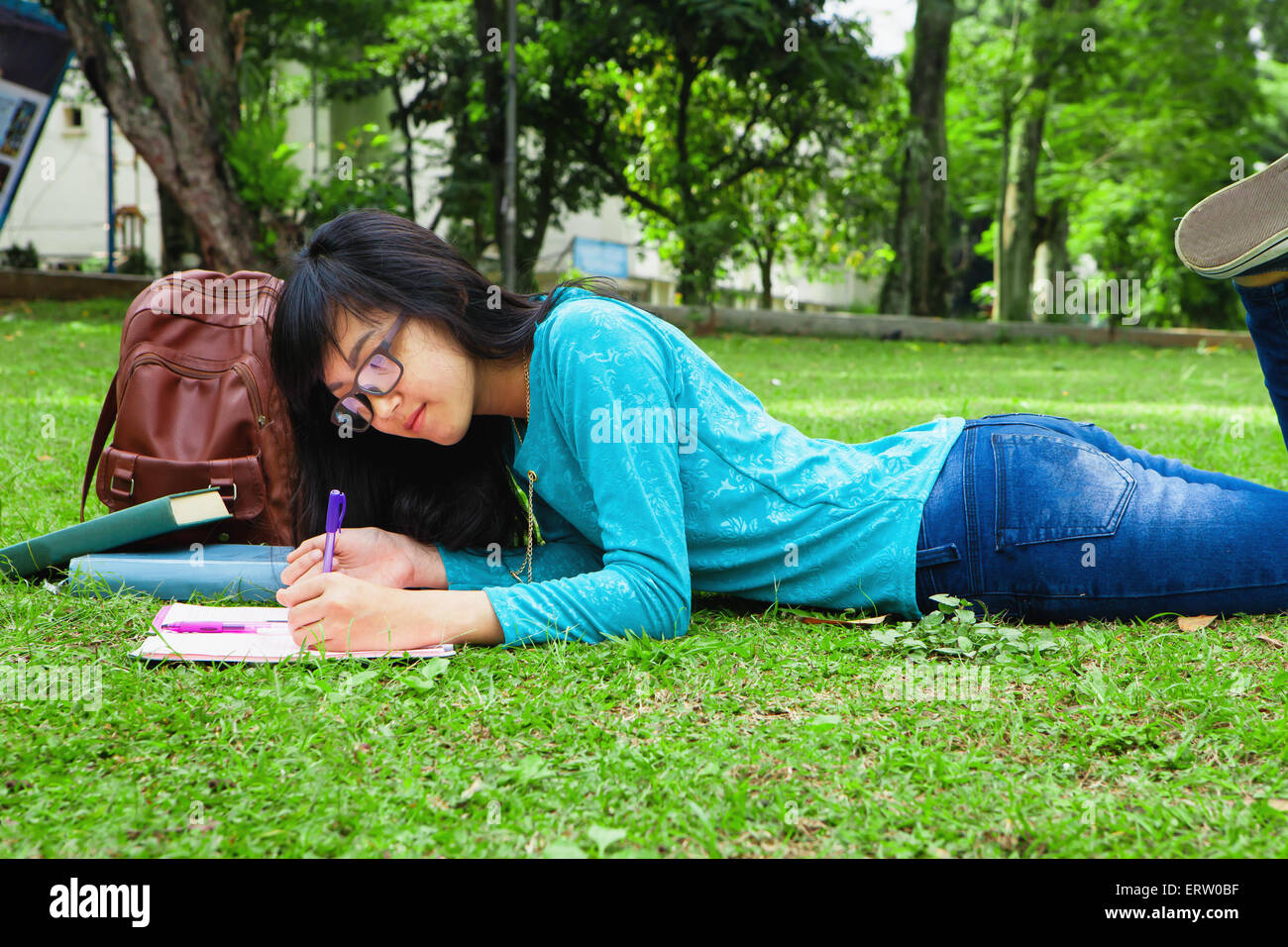 Uno studente universitario iscritto home lavorare all'aperto in università Foto Stock
