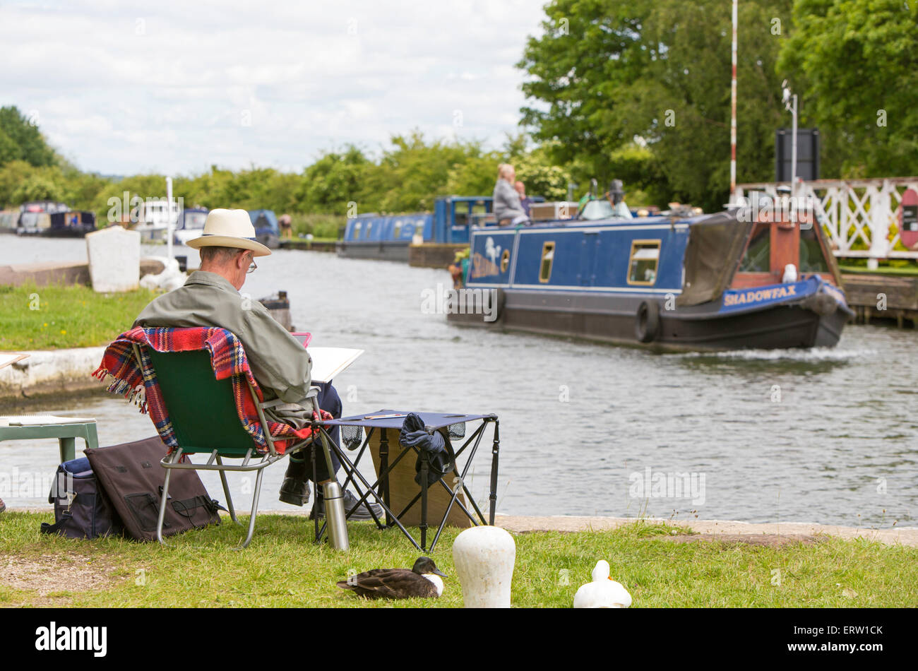 Un artista maschile disegno alla giunzione di Saul su Gloucester e Nitidezza Canal, Gloucestershire, England, Regno Unito Foto Stock