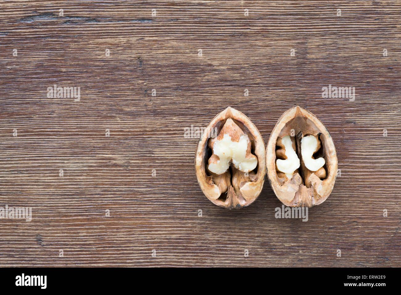 Aprire noci tagliate a metà sull'annata sullo sfondo di legno Foto Stock