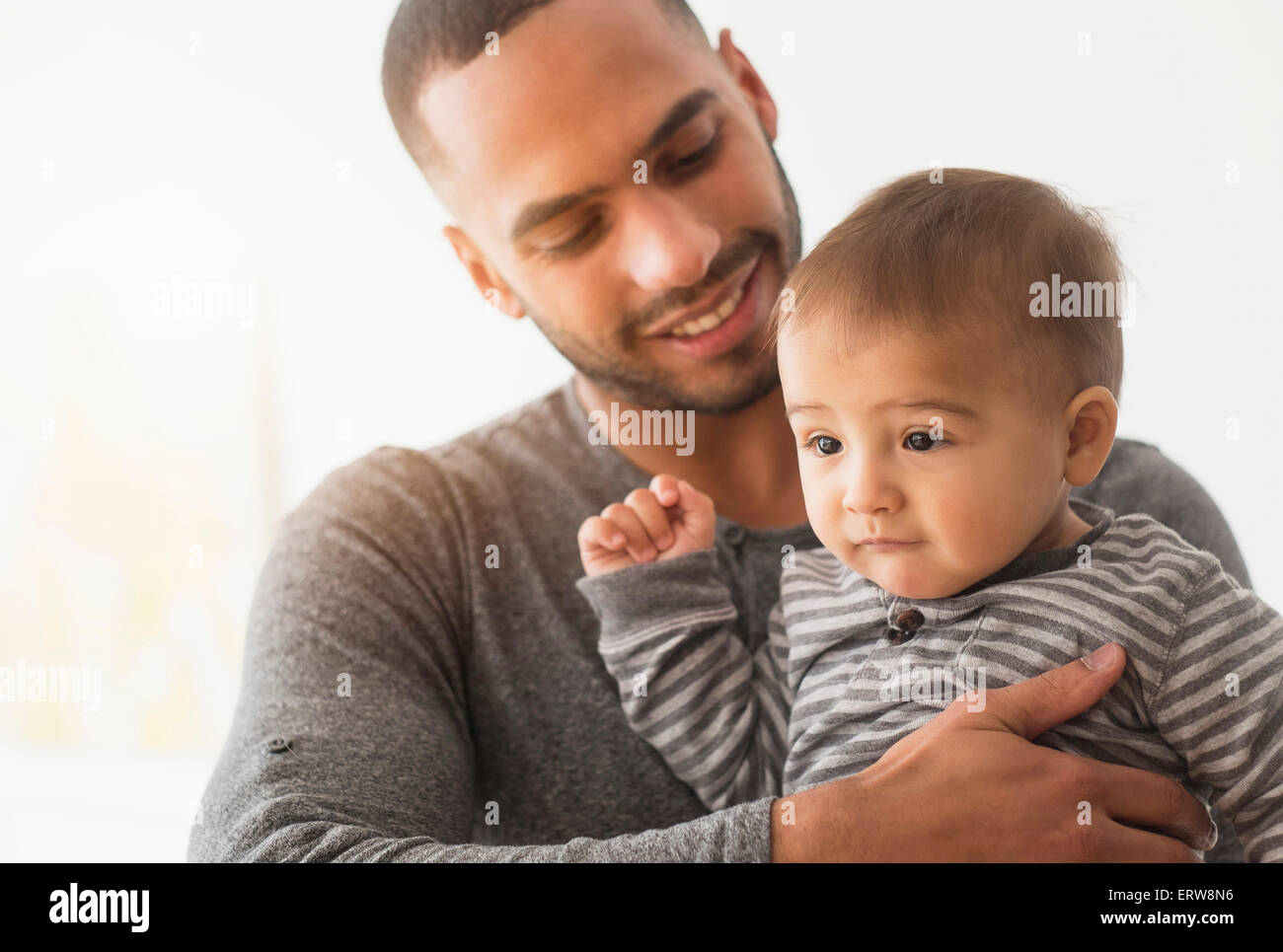 Padre sorridente holding baby figlio Foto Stock