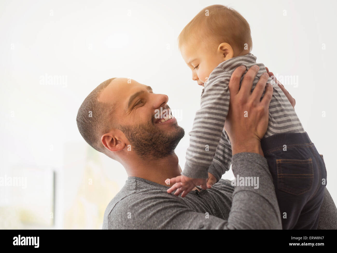Padre sorridente giocando con il bambino figlio Foto Stock