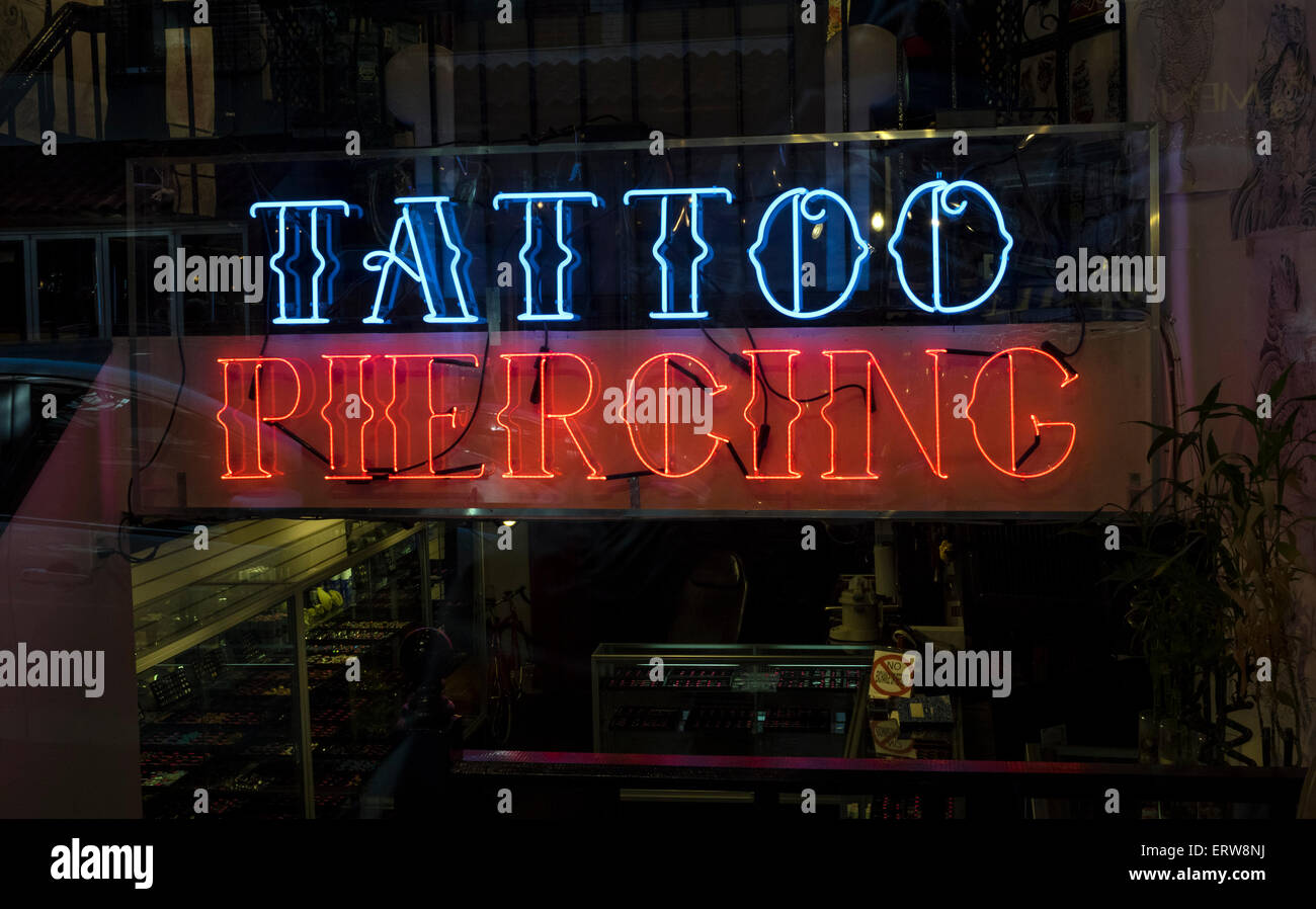 Una scritta al neon nella finestra di un Tatuaggio e pearcing shop in New York City Foto Stock