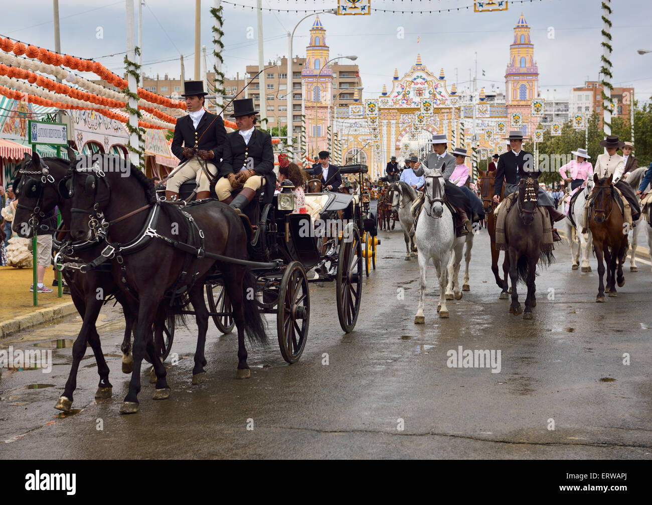 Carrozze trainate da cavalli e le donne sul cavallo sidesaddle su Antonio Bienvenida street cancello principale 2015 Siviglia fiera di aprile Foto Stock