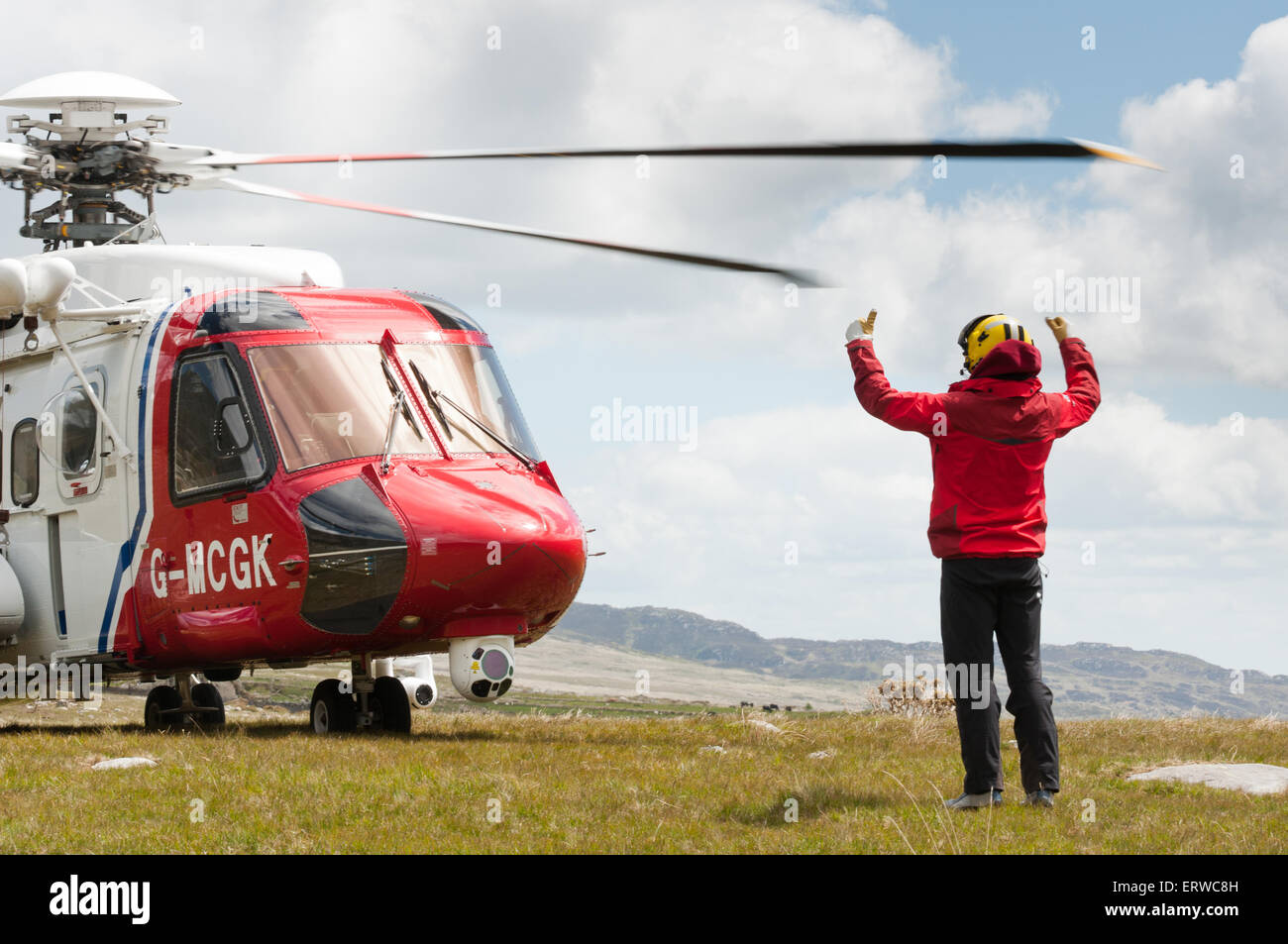 Un winchman esegue il marshalling di un Bristow la ricerca e il salvataggio Sikorsky S-92 elicottero come si inizia i suoi motori in Valle Ogwen, Galles Foto Stock