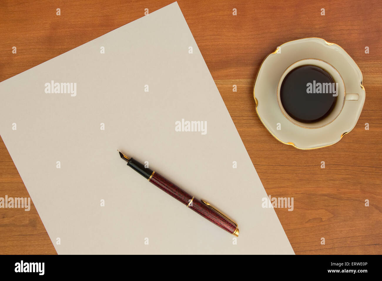 In procinto di scrivere una lettera. Penna, il bianco della carta da ufficio e una tazza di caffè nero sulla scrivania in legno. Foto Stock