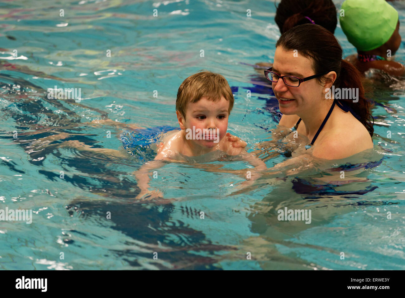 Un giovane ragazzo (due e una metà di anni) imparare a nuotare Foto Stock