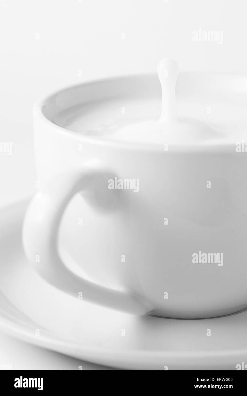 Schizzi di latte nella tazza da caffè Foto Stock