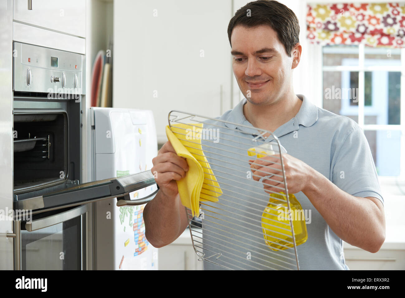 Uomo di pulizia forno domestico in cucina Foto Stock