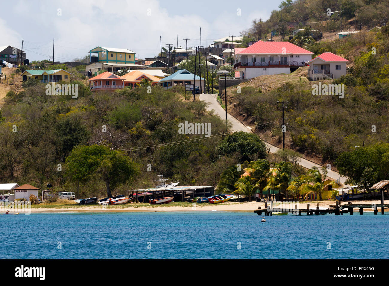 Vista della spiaggia, barche, Jetty e case; la soluzione Salina Bay, Mayreau, Saint Vincent e Grenadine. Foto Stock