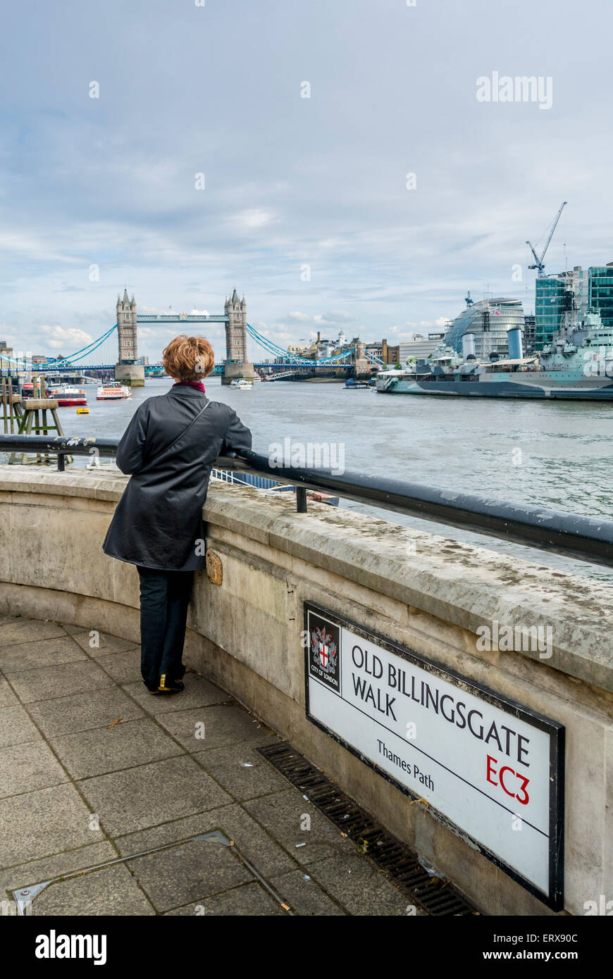 Femmina su Old Billingsgate a piedi con il Tower Bridge in background. Foto Stock