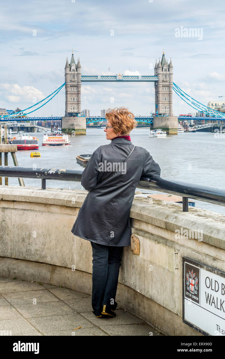 Femmina su Old Billingsgate a piedi con il Tower Bridge in background. Foto Stock