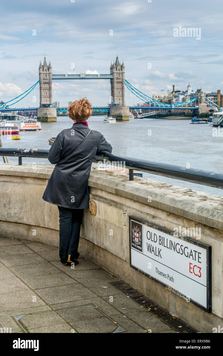 Femmina sulla vecchia Billingsgate passeggiata guardando verso Tower Bridge. Londra. Foto Stock