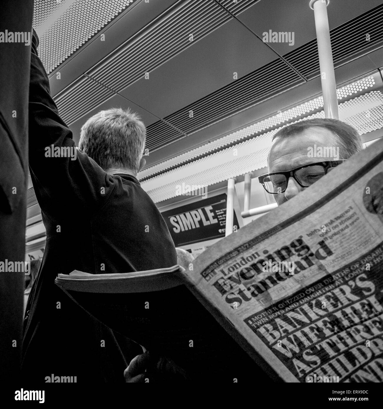 L'uomo sul tubo la lettura del treno di sera giornale Standard Foto Stock