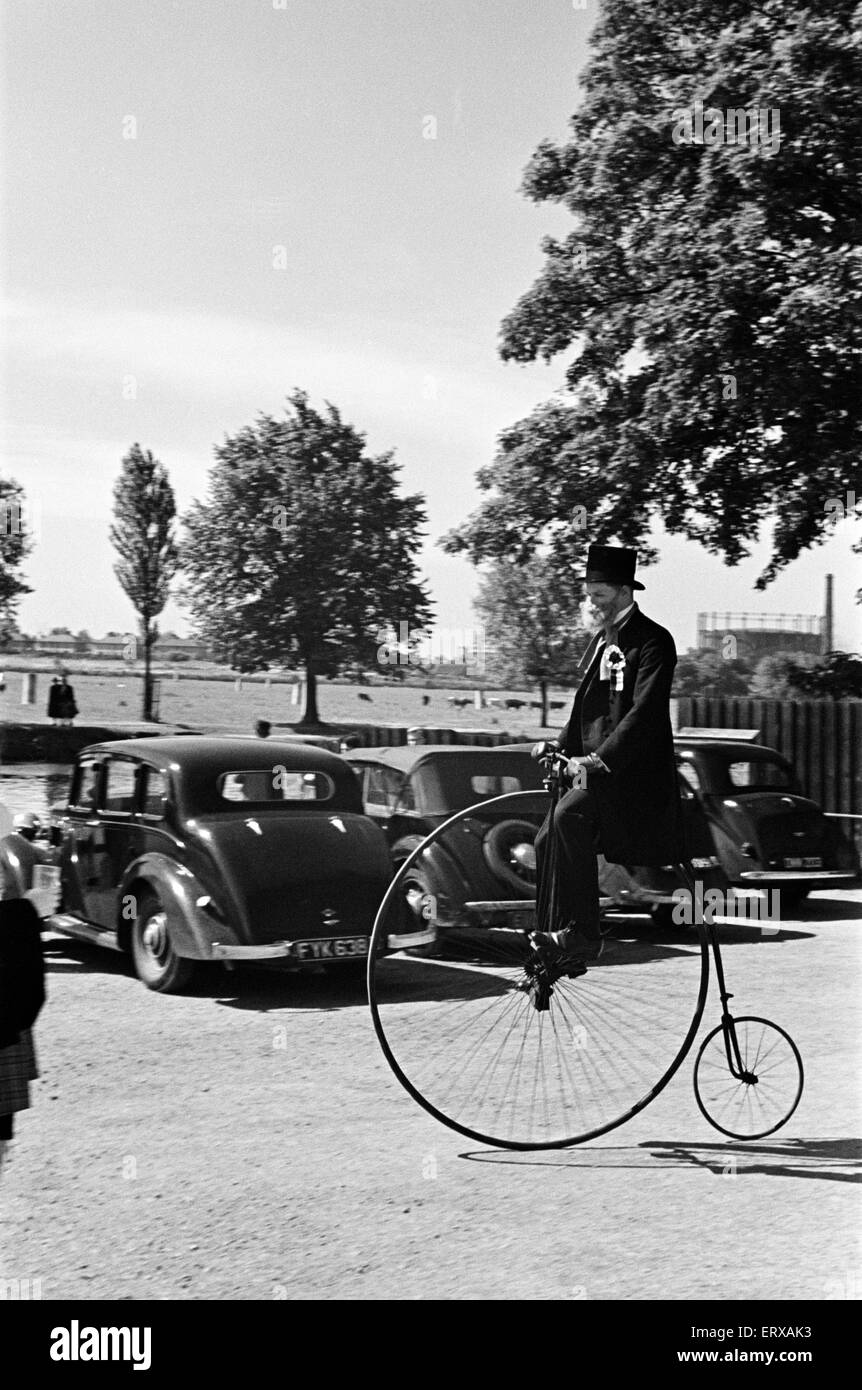 Un uomo vestito in abiti in stile vittoriano, indossando un falso di barba e a cavallo di un penny farthing come parte del 'Cambridge va Gay" celebrazioni. Cambridge, Cambridgeshire, Giugno 1947. Foto Stock