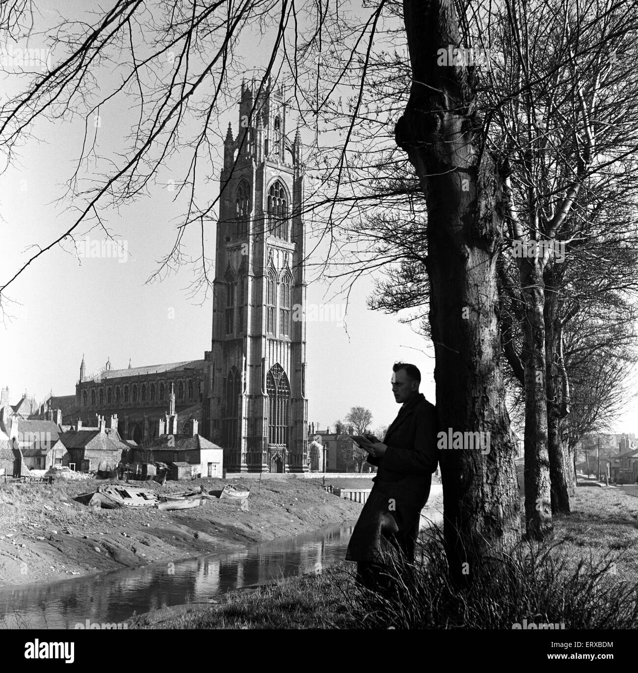 Un uomo la lettura vicino a St Botolph's chiesa di Boston, Lincolnshire. Il 2 aprile 1953. Foto Stock