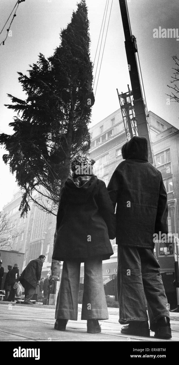 Due ragazzi lo sguardo verso l'alto e la parte superiore dell'albero di Natale come operai collocarlo in Church Street, Liverpool. 3 Dicembre 1972 Foto Stock