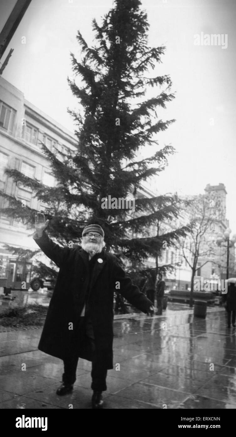 Liverpool Street musicista Augusto Broll fa una maschera intorno a un albero di Natale in Church Street. 25 Novembre 1982 Foto Stock