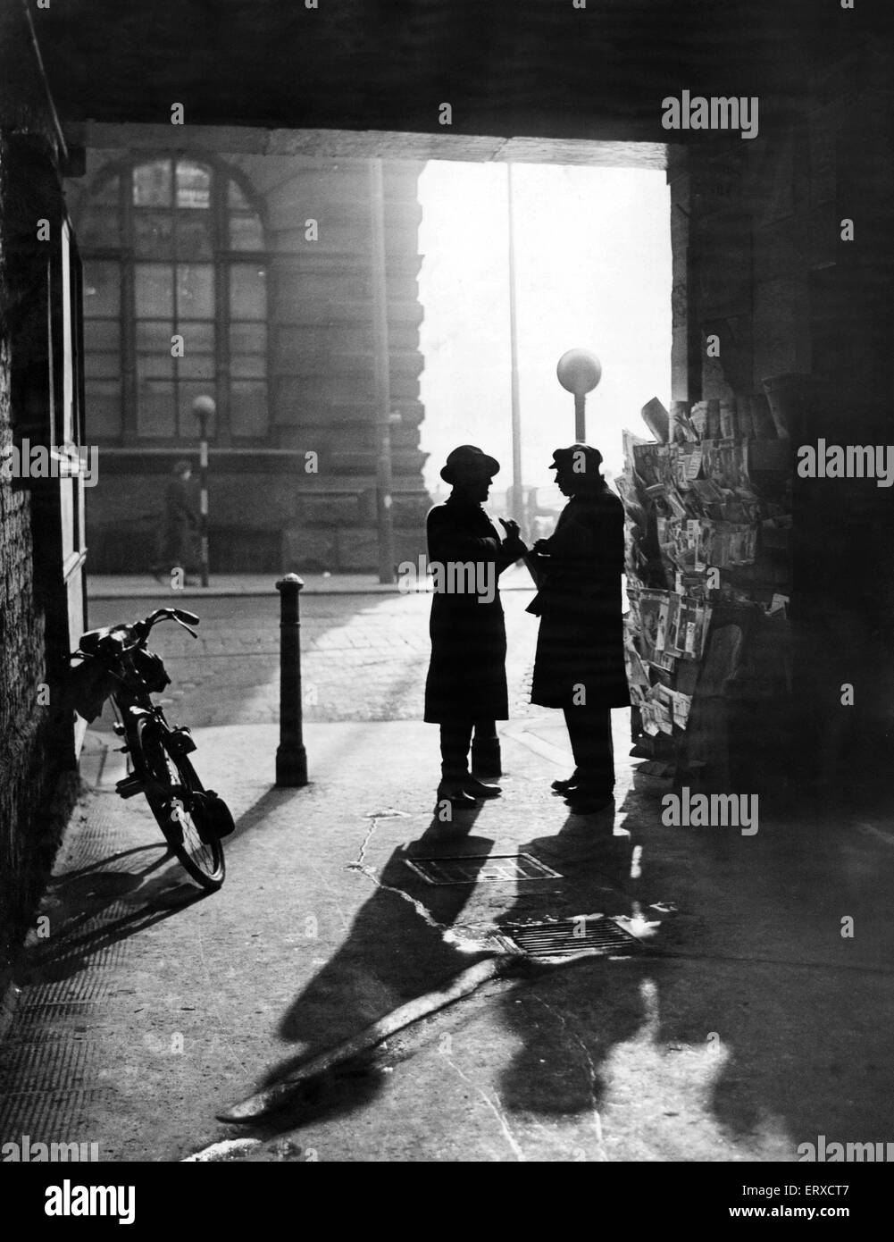 Un uomo che parla di un venditore di giornali sotto l'entrata coperta di cuoio Lane, Off Dale Street, Liverpool. Il 17 gennaio 1950 Foto Stock