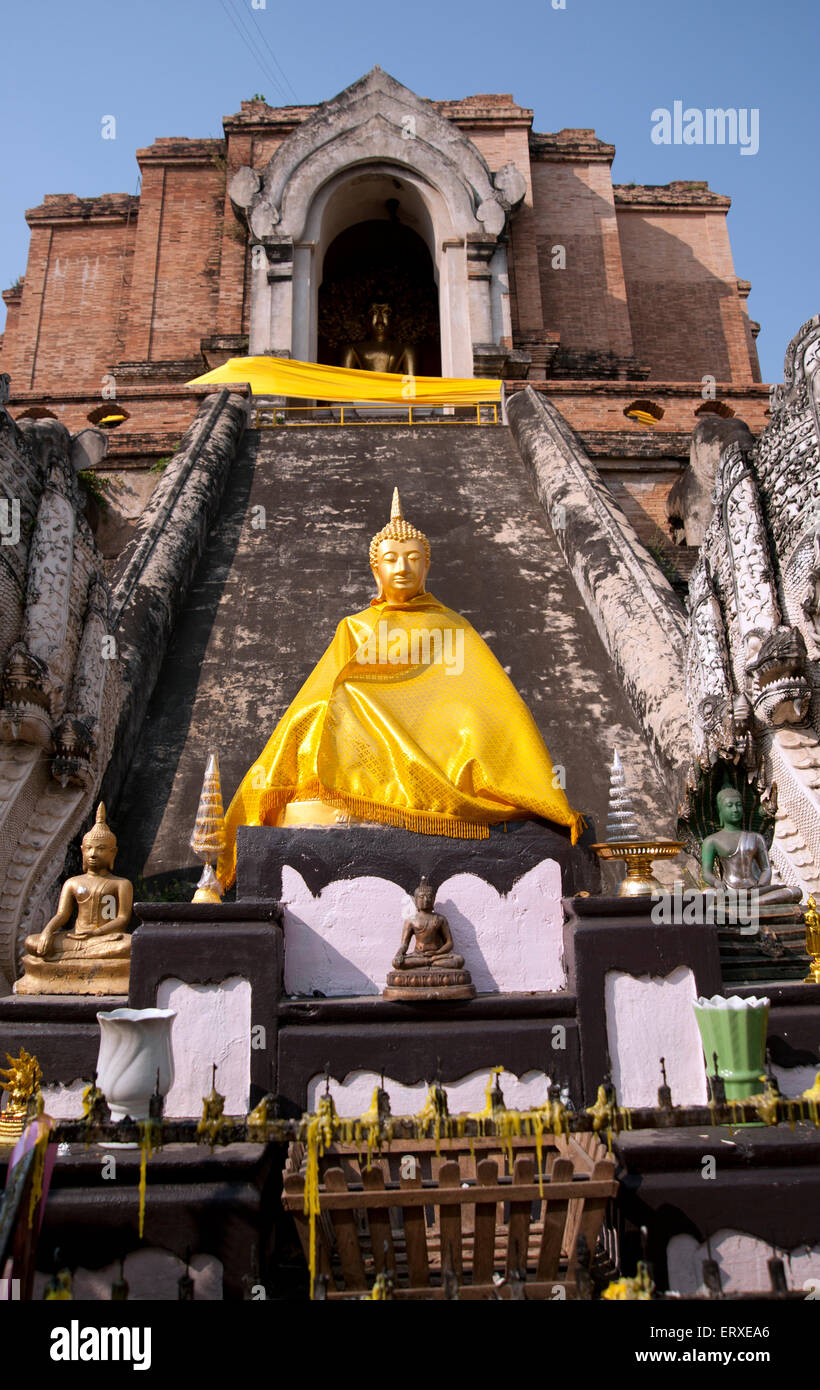 Oro statua del Buddha vestito in abiti dello zafferano sul fondo del tempio di pietra passi in Chiang Mai Thailandia Foto Stock