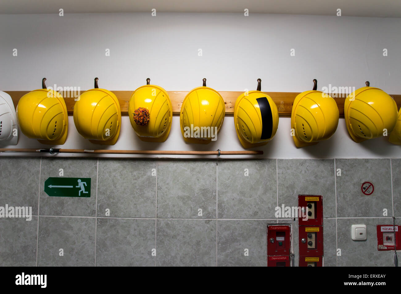 Costruzione gialla cappelli appesi a un rack, uno di loro ha una frangia su di esso Foto Stock Costruzione gialla cappelli appesi a un rack, uno di loro ha una frangia su di esso Foto Stock