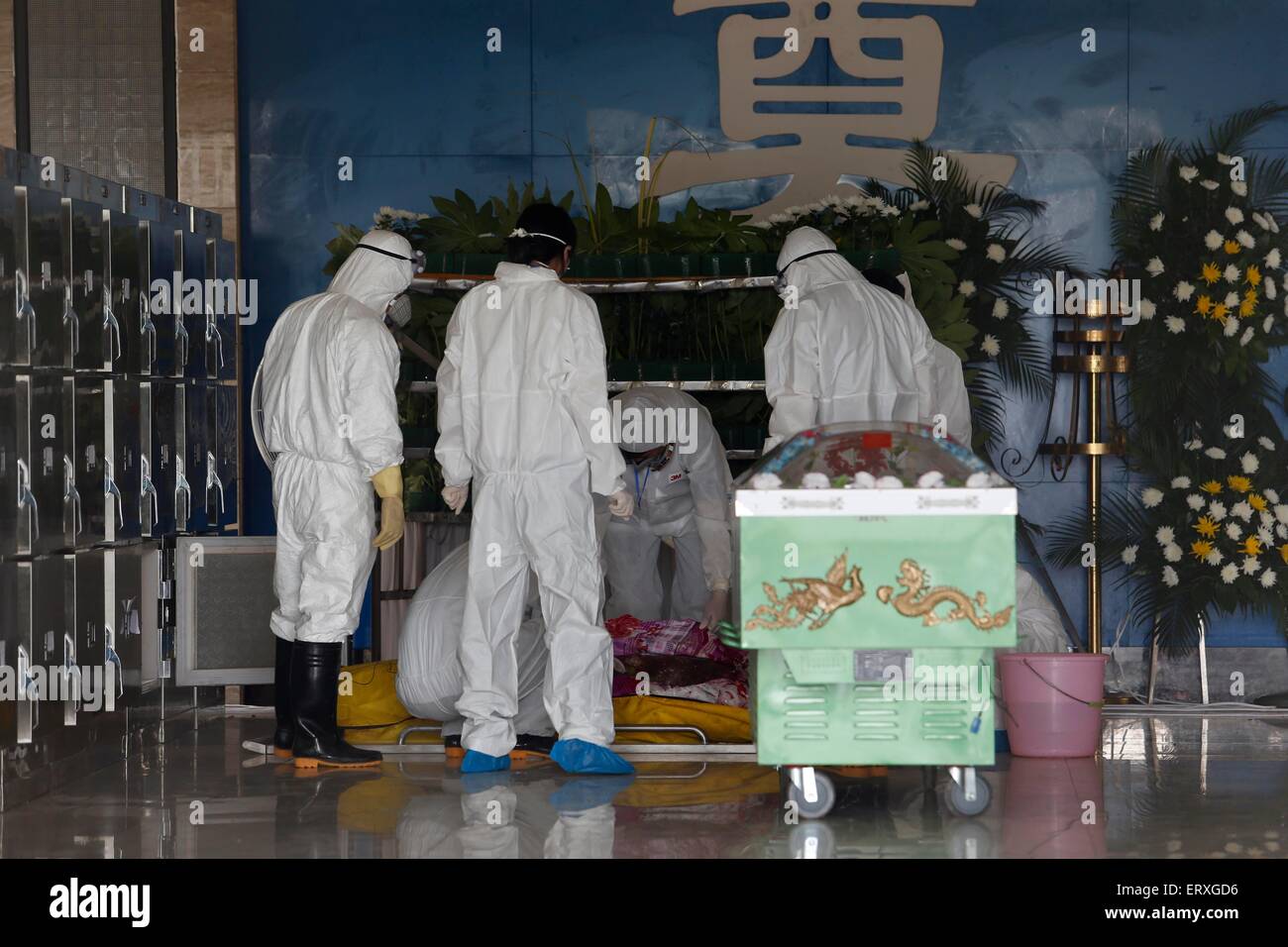 Jianli, Cina. 09 Giugno, 2015. Lavoratori portano il corpo delle vittime del affondò la nave ''Eastern Star'' per preparare le persone prestando la loro ultima rispetti a resti di nella contea di Jianli, provincia di Hubei, Cina centrale, 9 giugno 2015. Vi sono stati 456 sul bordo della stella cometa quando è affondato in caso di brutto tempo al 01 giugno. 14 persone sono state soccorse viva dopo la nave affondò. Finora, 406 morti nel disastro. Credito: Panda occhio/Alamy Live News Foto Stock