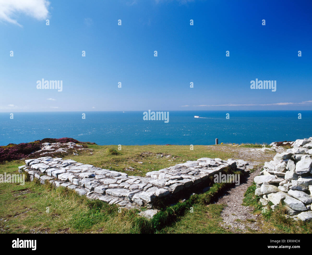 Fondamenti di pietra di un C4° Roman torre di avvistamento sulla cima della montagna di Holyhead, Anglesey, cercando W su Gogarth Bay. Foto Stock