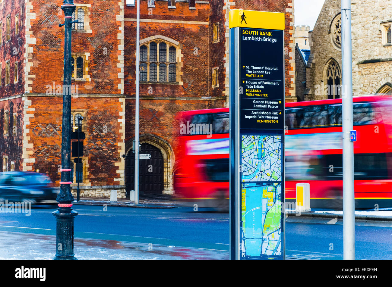 Indicazioni post nella Southbank, con i famosi taxi neri e bus rosso passando in background in Londra. Foto Stock