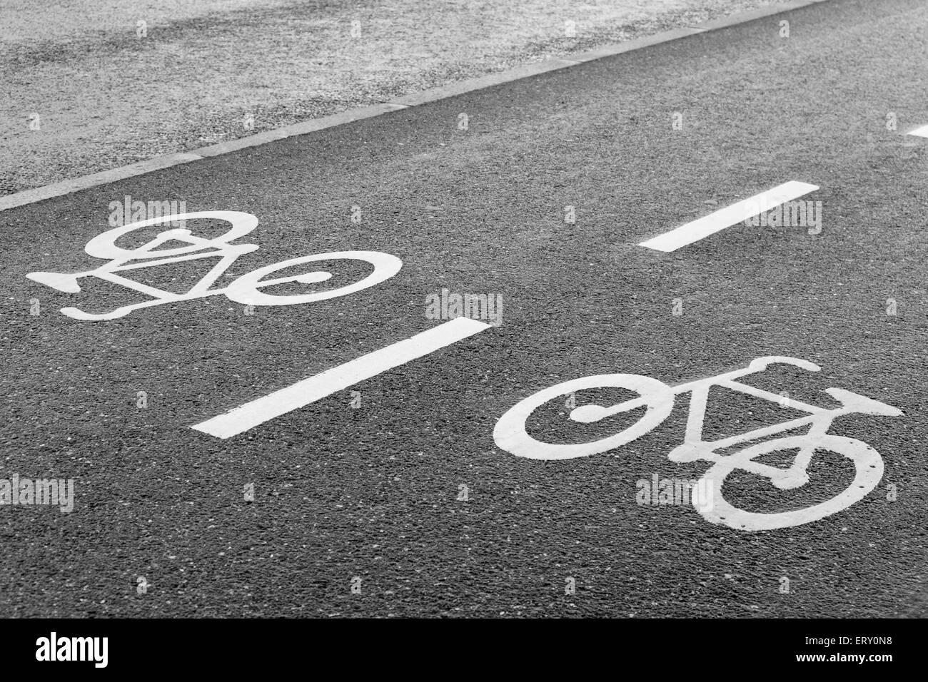 Bicicletta segno su strada a doppia corsia su asfalto bagnato Foto Stock