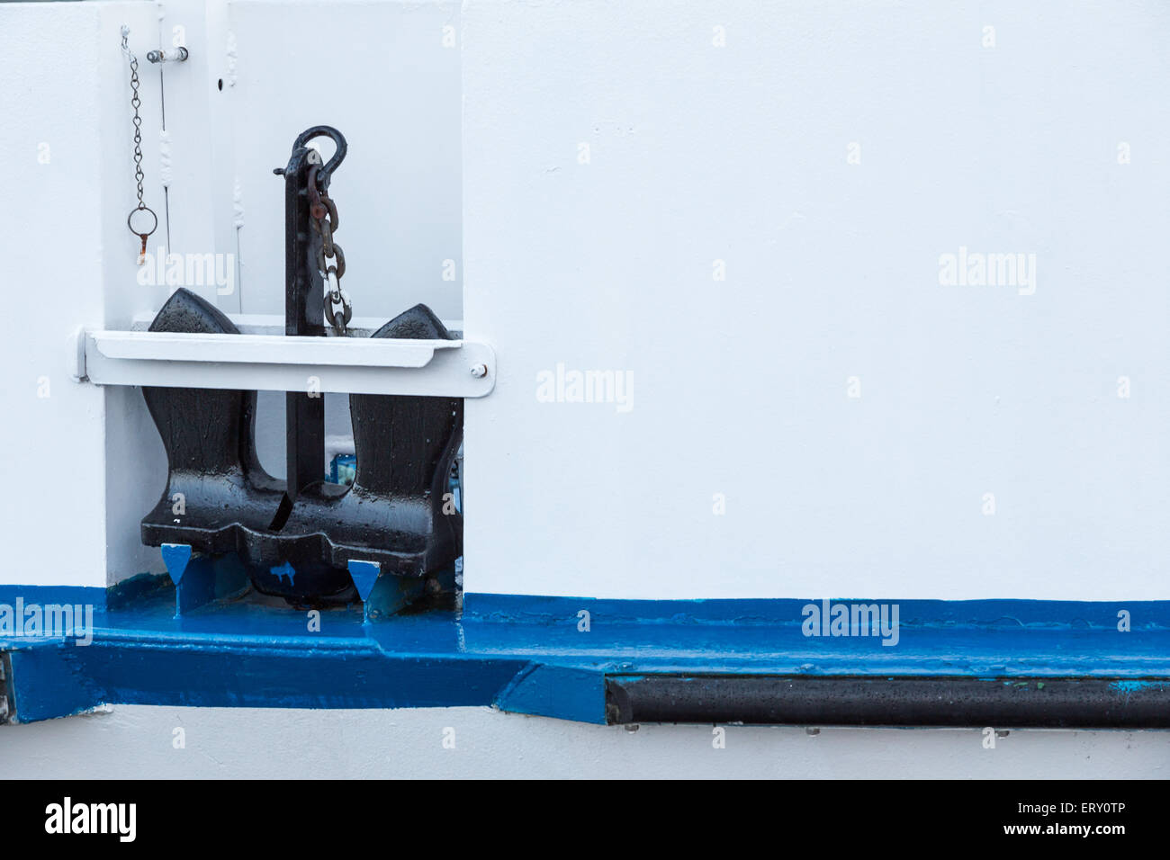 Un ancoraggio nero a bordo di un bianco e blu barca Foto Stock