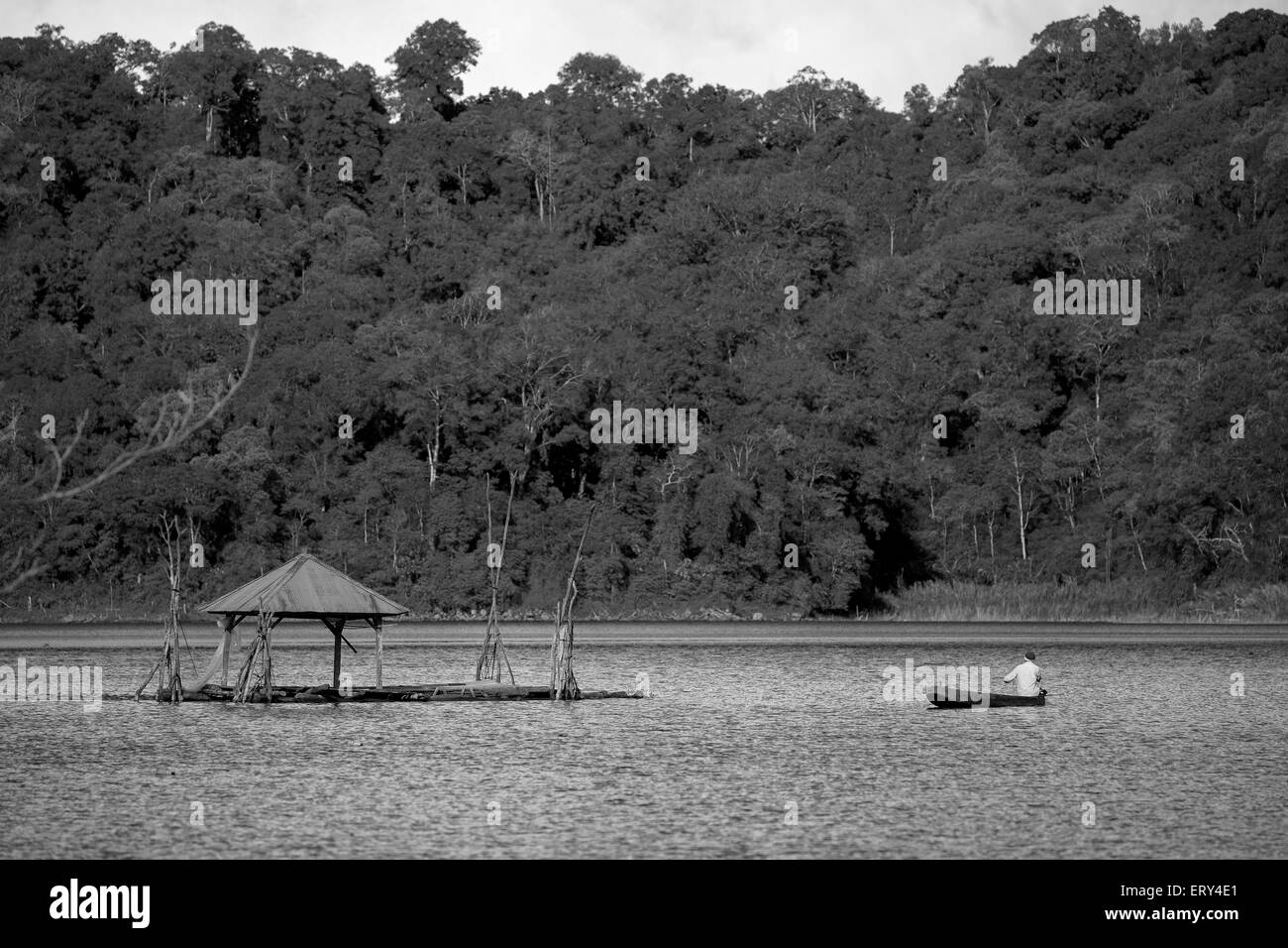 Un solo uomo canottaggio canoa il suo andare a pesca nel Lago Buyan Foto Stock