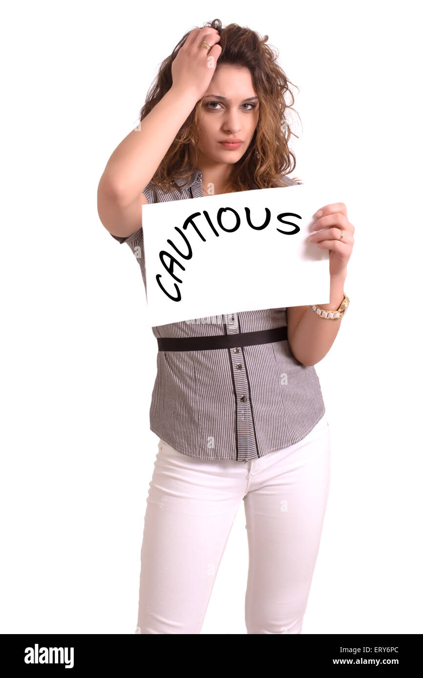 Giovane donna attraente tenendo la carta con cautela il testo su sfondo bianco Foto Stock