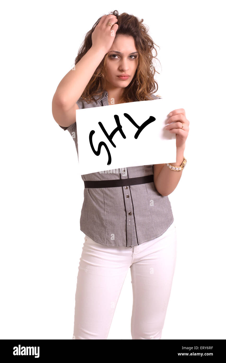 Giovane donna attraente tenendo la carta con timido testo su sfondo bianco Foto Stock