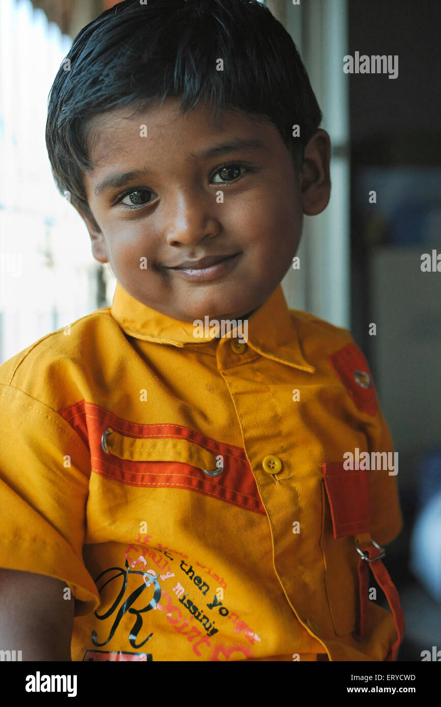 Ragazzo indiano in camicia gialla ; guardando la macchina fotografica , India , asia Foto Stock