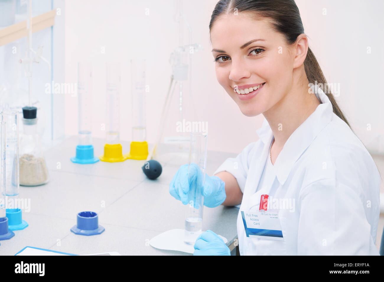 Laboratorio chimico scena: attraente giovane studente scienziato osservando Misure per liquidi, il concetto di medicina Foto Stock