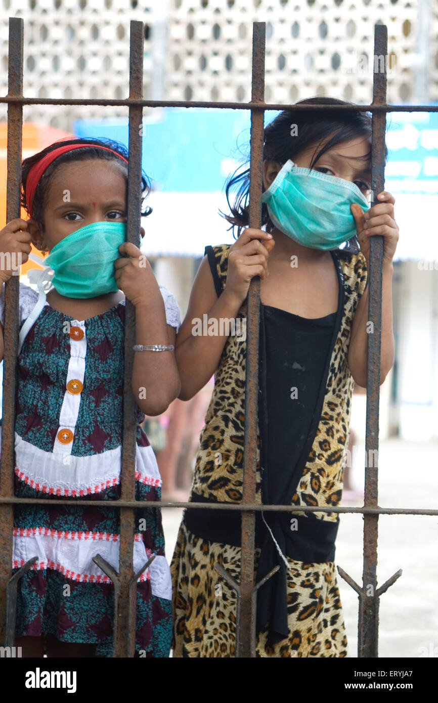 Bambini che indossano una maschera per evitare virus influenzali , Bombay , Mumbai , Maharashtra , India , Asia Foto Stock