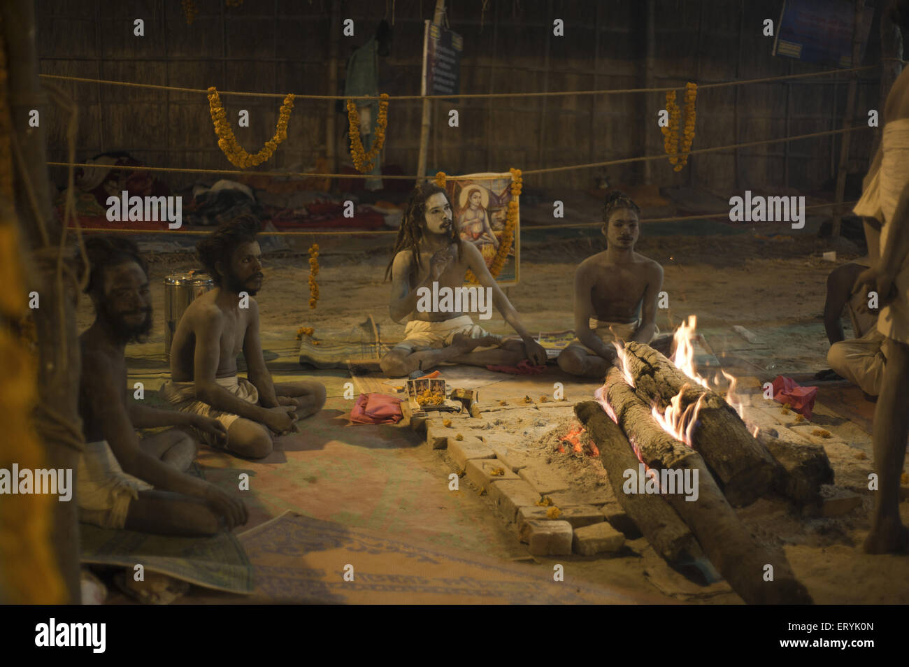 Sacerdote con fuoco di legno Kumbh Mela Festival in Uttar Pradesh, India Foto Stock