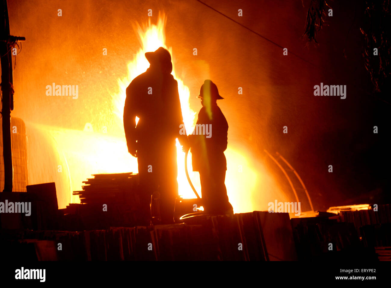 Vigili del fuoco personale raffreddare gli incendi scoppiati in cisterna di GPL con acqua scatti a Kurla ; Mumbai Bombay ; Maharashtra ; India Foto Stock