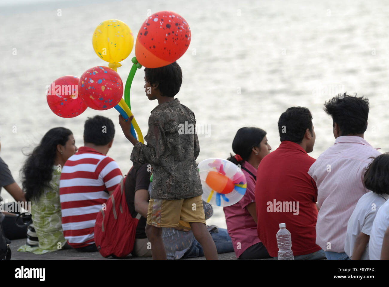 Giovane ragazzo vende palloncini colorati per i turisti in visita a Marine Drive in Mumbai Bombay ; Maharashtra ; India Foto Stock